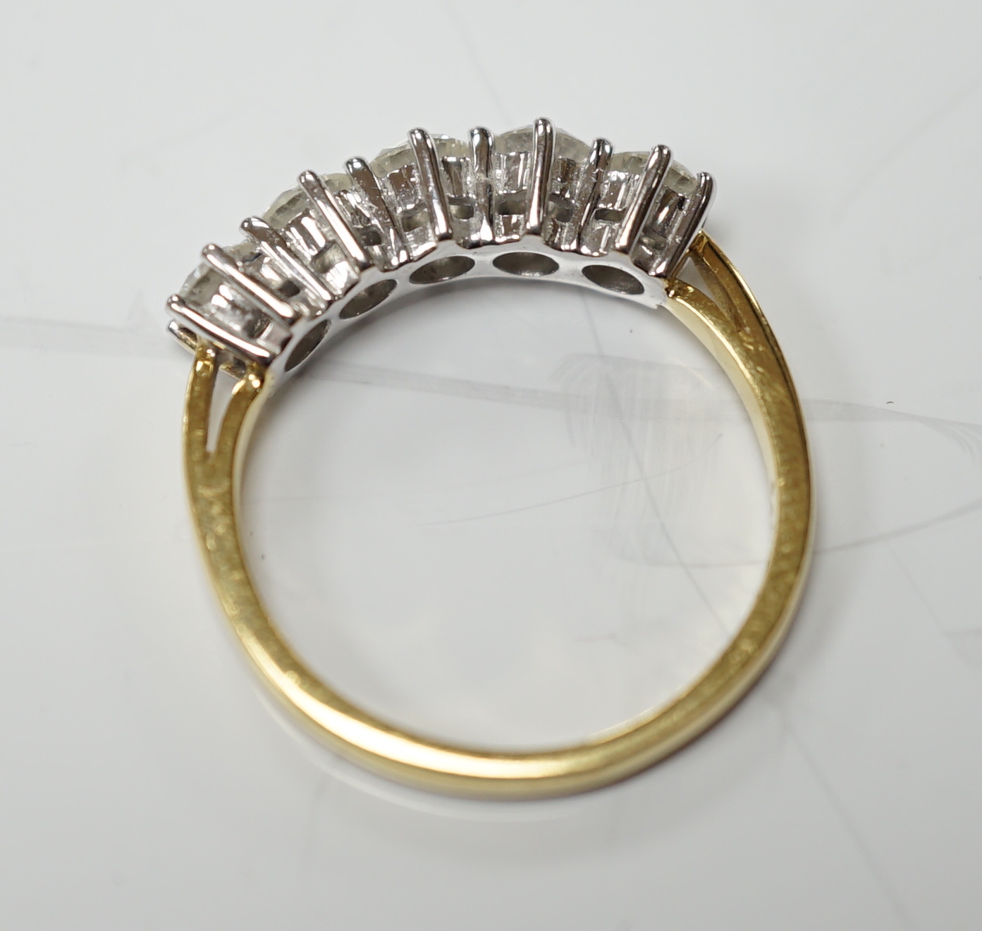 A modern 18ct gold and five stone diamond set half hoop ring, size N, gross weight 4 grams.